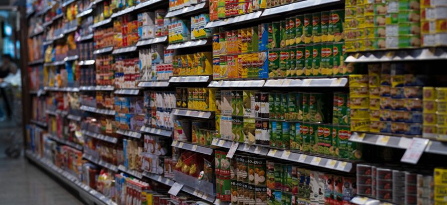 Ряды консервированных продуктов на полках магазина